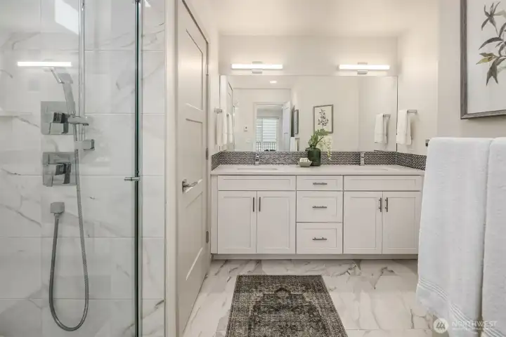 Primary bath with vanity with double sinks, large walk in shower and separate W/C.