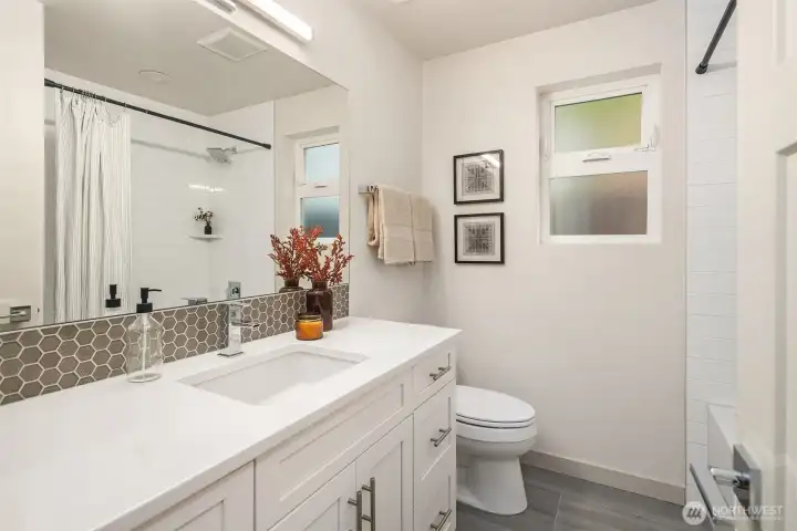 Main floor full bath with deep soaking tub and large vanity.