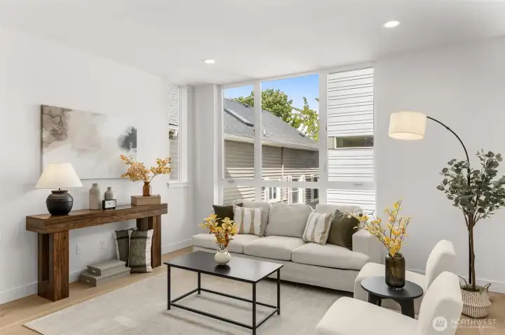 Open-concept living room bathed in natural light from large-format windows.