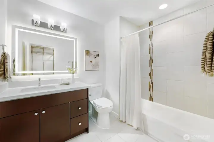 The spacious primary bath is stylishly appointed with modern fixtures and an LED anti-fog mirror.