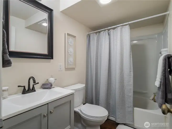 The bathroom has a full bathtub, and storage in the vanity.