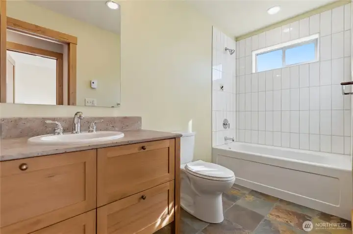 Upstairs full bath with tile shower and custom vanity, quartz counter top.
