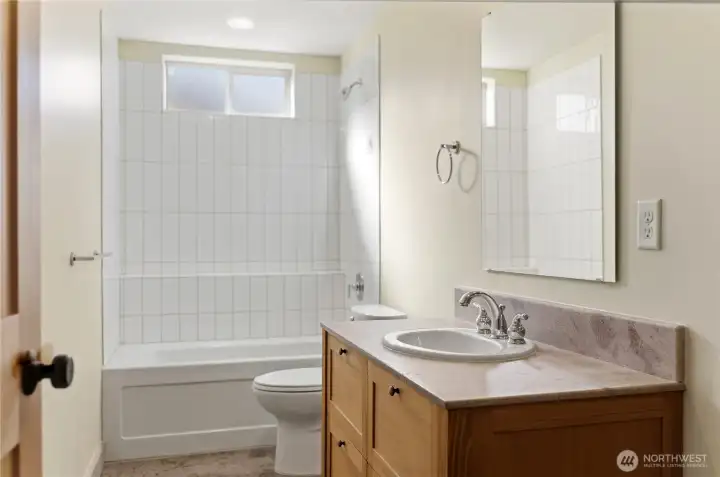 Upstairs full bath with tile shower and custom vanity, quartz counter top.