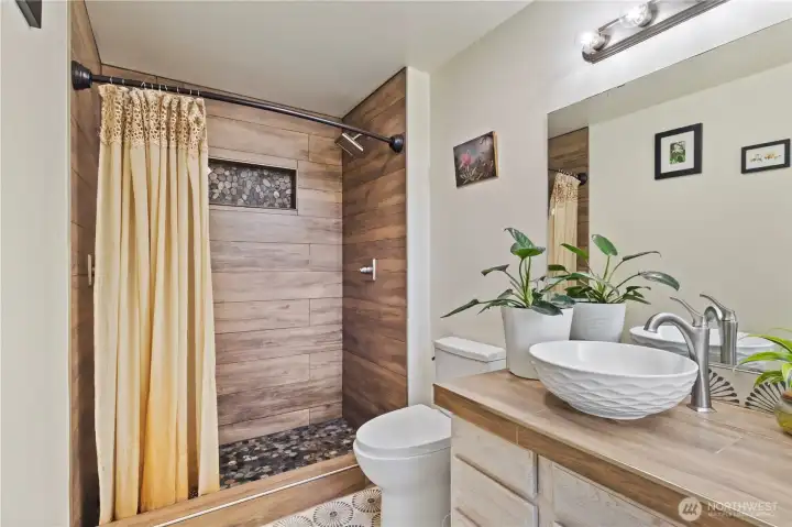 Beautiful tiled shower with 2 shower heads.