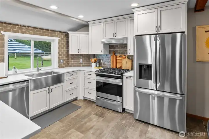 Renovated kitchen with custom cabinets and stainless steel appliances.