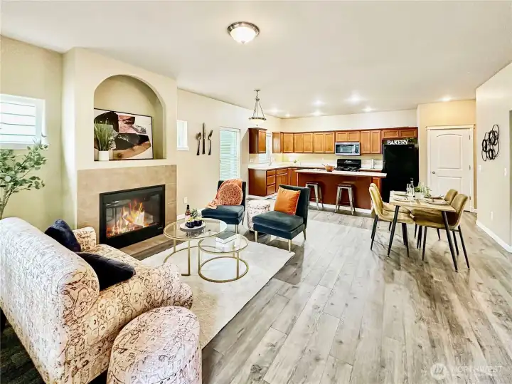 The Great Room...View from the front entry.  Rich laminate flooring throughout, cozy gas log fireplace and access to covered patio just off the dining area.