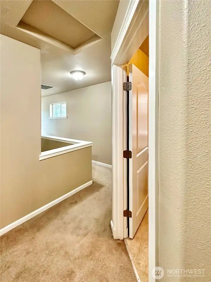 Upper floor hall shows the laundry room access.
