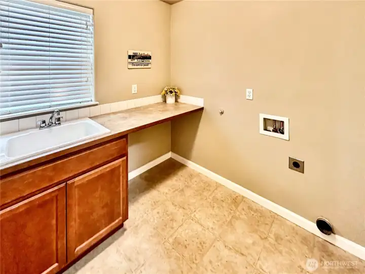 Upper floor laundry room with sink and counter space.