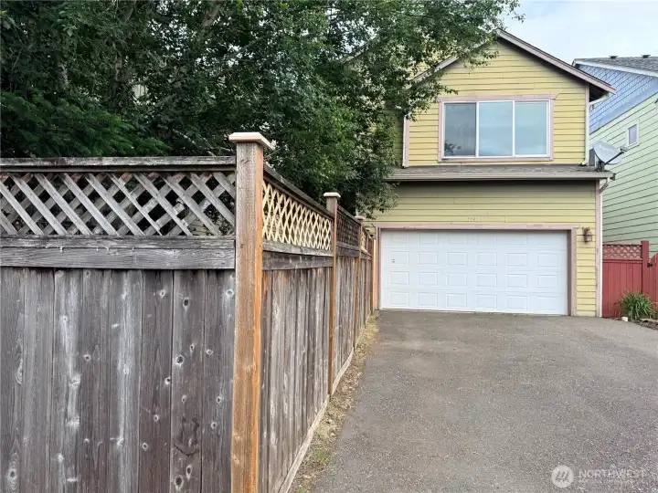 Back view of the home showing the off street parking and attached 2 car garage.