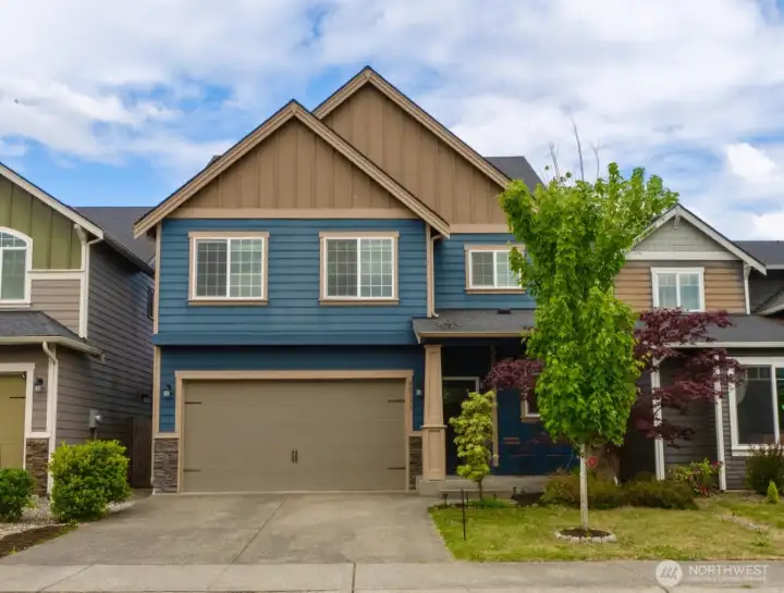 Beautiful curb appeal featuring stylish exterior finishes, thoughtful landscaping, and a welcoming covered entry.