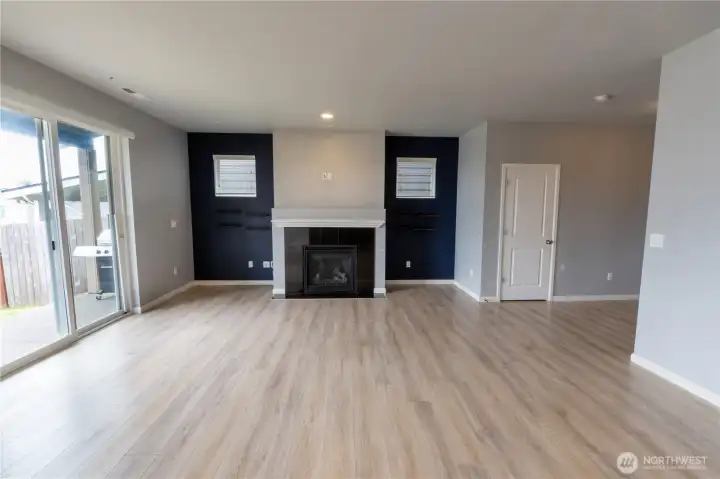 Open and airy living room with a gas fireplace and seamless flow to the kitchen and dining areas.
