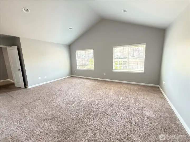 Expansive primary suite with vaulted ceilings and abundant natural light