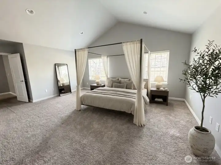 Virtually staged primary suite showcasing the generous space and vaulted ceilings