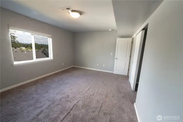 Generously sized upstairs bedroom with abundant natural light and flexible living space.