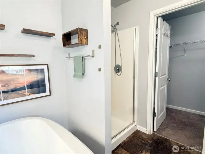 Relax in the spa-inspired primary bath with a soaking tub and separate walk-in shower leading to a walk-in closet