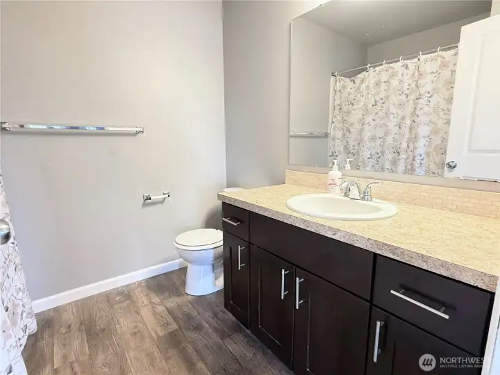 Second-floor full bathroom conveniently located across the hall from the secondary bedrooms, featuring a spacious vanity and tub/shower combination.