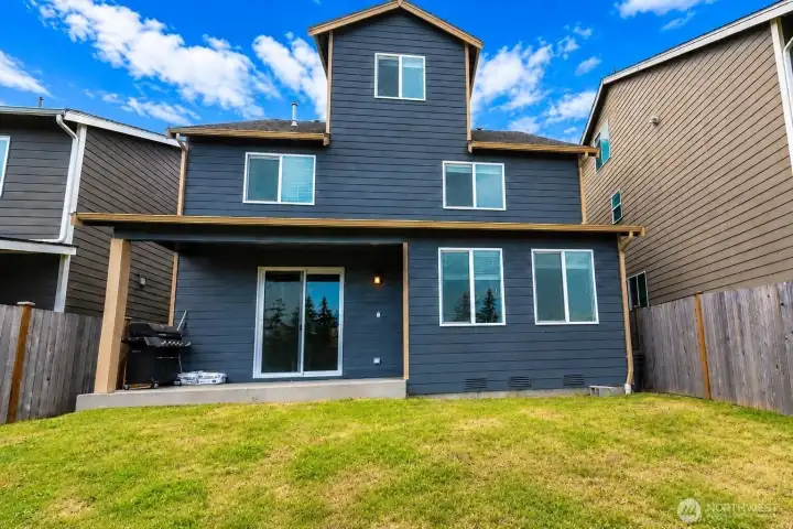 Rear exterior showcasing the covered patio and fully fenced backyard.