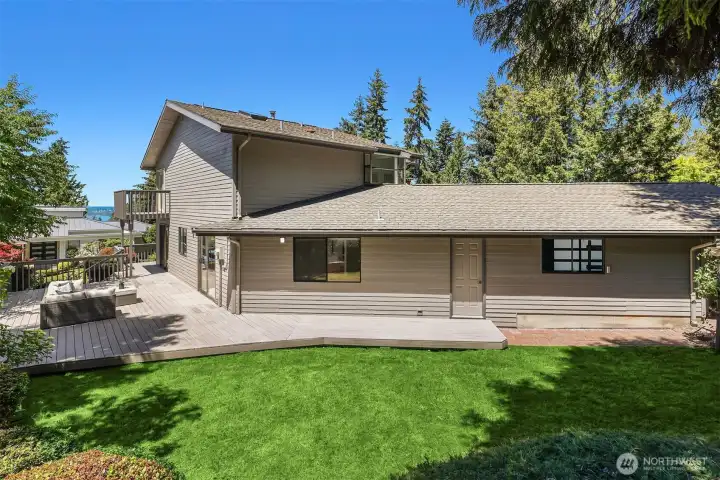 Large entertaining deck wraps around two sides of the house, while still giving plenty to lawn space to play and put your toes in the soft grass