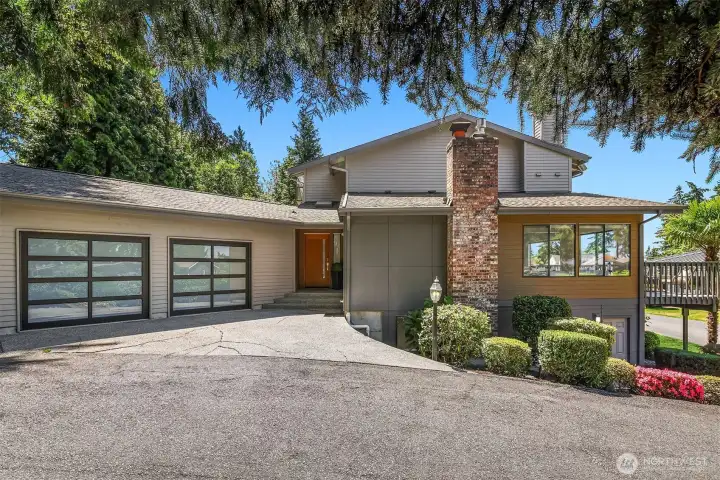 A two car garage, with newer garage doors and EV charging. The exterior of the home is freshly repainted