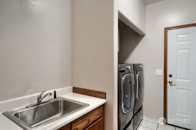Laundry room with door to the 4 car garage.  Note the Washer and Dryer remain with the home.