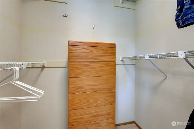 A walk-in closet is in the primary suite, with loads of room for garments and even the dresser.
