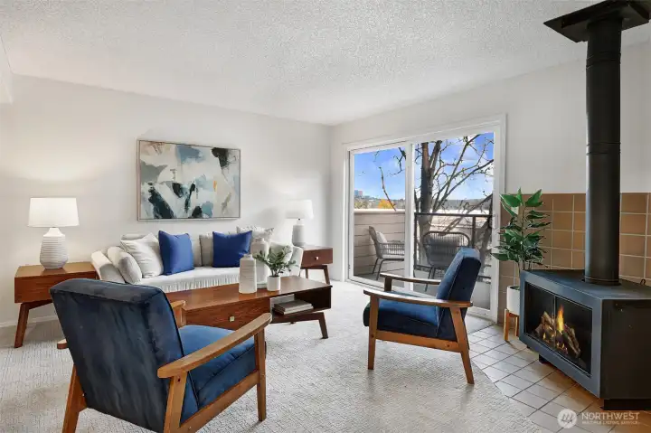 Living spaces are bright, inviting, and comfortable. A sweet mid-century inspired stove adds warmth and ambiance to the space.