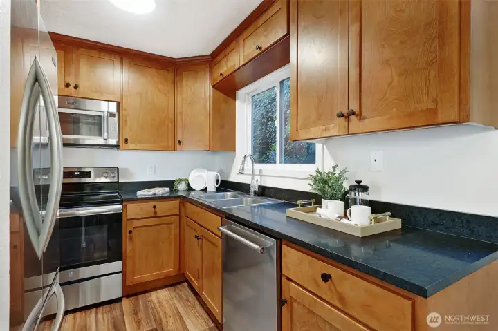 Black granite counters, solid wood cabinetry, and newly installed range, dishwasher and fridge - this kitchen is a delight!