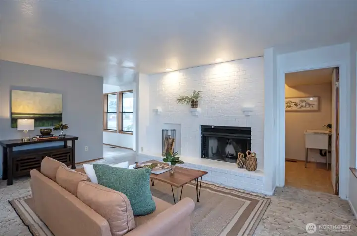 Beautiful brick fireplace, accent wall, and laudnry room with utility sink.