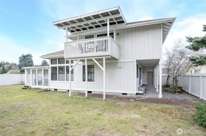 Backyard with access to garage, primary deck and sun room wiht sliding door