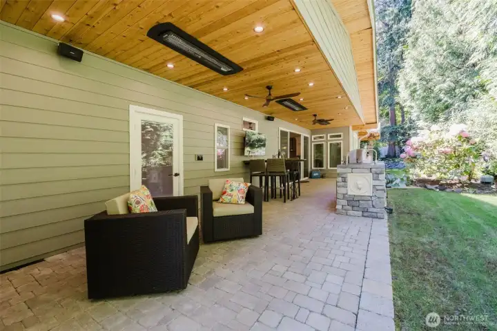 Backyard patio features ceiling fans and Bromic electric outdoor heaters.