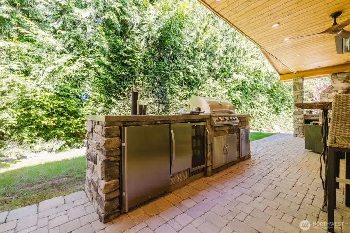 Outdoor kitchen with grill, fridge, icemaker, 2 tap kegerator, sink.