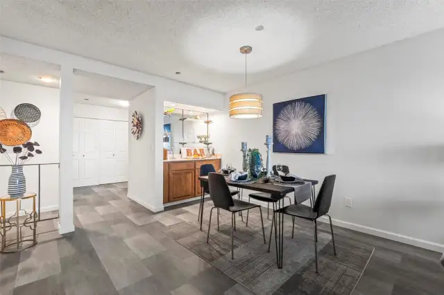The retro wet bar adds a unique touch of charm and character, perfectly positioned next to the open dining area with modern lighting that creates a warm, inviting ambiance.