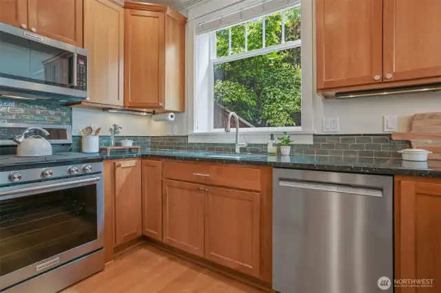 Abundance of kitchen cabinets, slab granite counter tops, tile back splash & window to green outlooks.