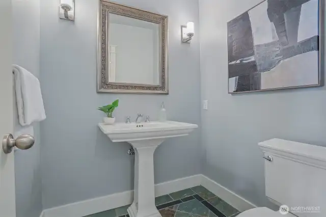 Main level slate power room with wall sconces and pedestal sink.