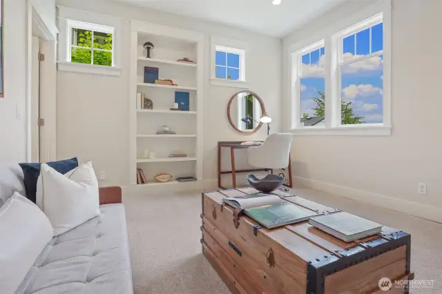 Lower level family room has built in book case, side lights, & corner windows.