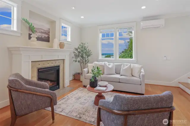 Living room has wide plank hardwoods, handsome tall ceiling. Gas fireplace, boxed mantel, ceramic tile surround, stone tile hearth.