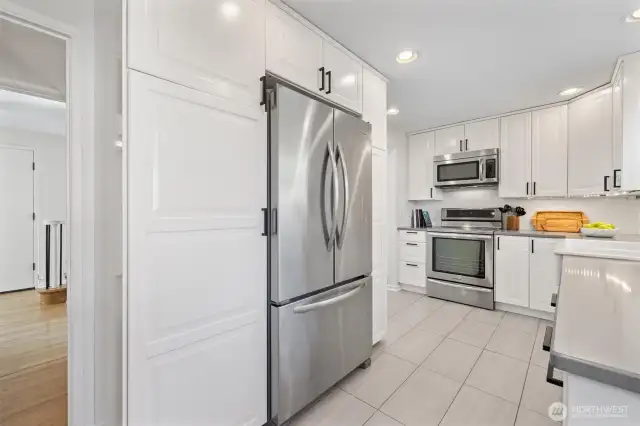 Stainless-steel appliances and cabinets are pantry-like with pull outs.
