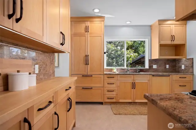 Maple cabinets anchor the custom-built kitchen, offering smart, floor-to-ceiling storage designed for real life.