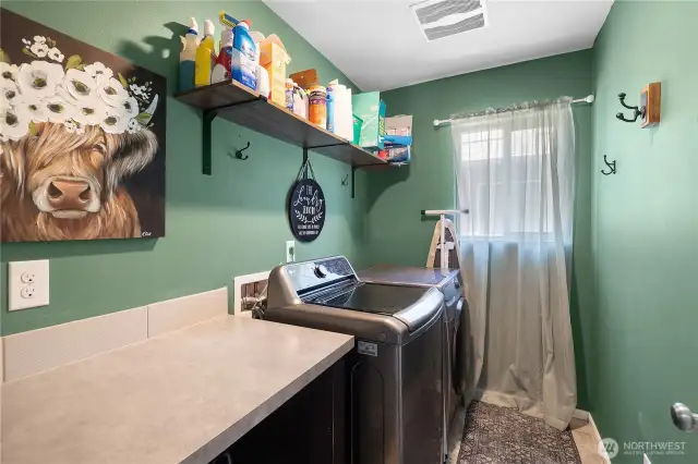 Laundry room on the same level as the bedrooms for convenience. Built-in counter with open storage below.