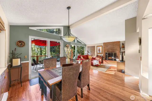 Dining area seamlessly flows from kitchen and into open living space, all with vaulted ceilings.