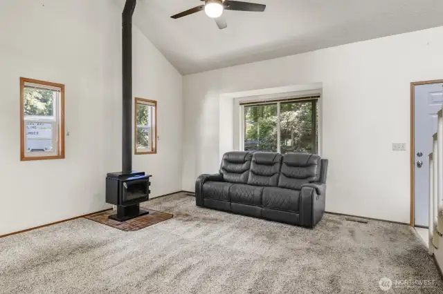 Come on in! Vaulted ceilings grace the living room with free standing wood fireplace.