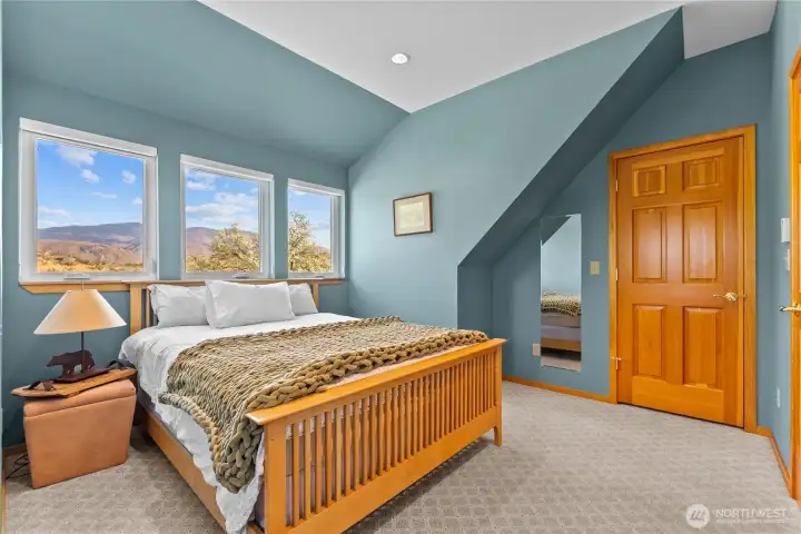 Upstairs bedroom with wood doors leading to closet.