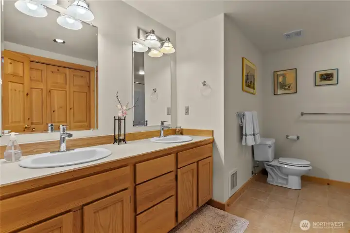 Downstairs full bathroom with 2 sinks and bright vanity lighting.