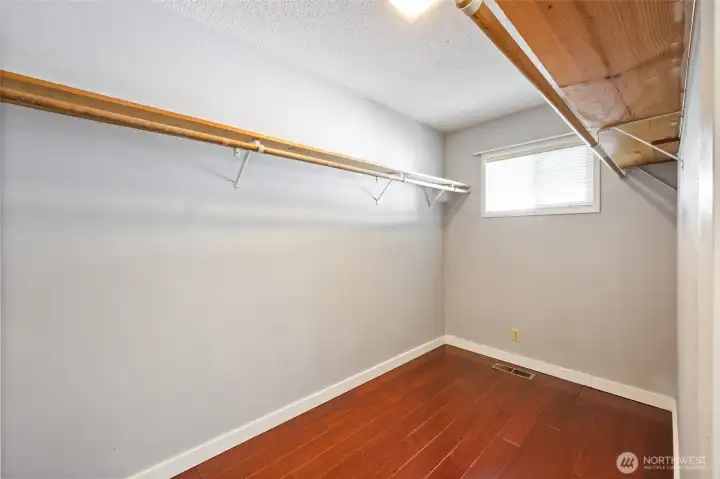 Large walk-in closet with window in primary bedroom.