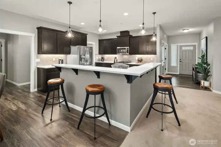 This chef-inspired kitchen pairs rich cabinetry with sleek quartz counters and pendant lighting — a stylish, functional space where cooking and conversation come together.