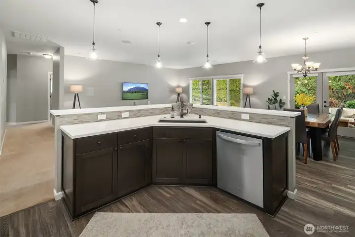 The kitchen island serves as both a gathering place and a functional hub — perfectly positioned for conversation and entertaining.