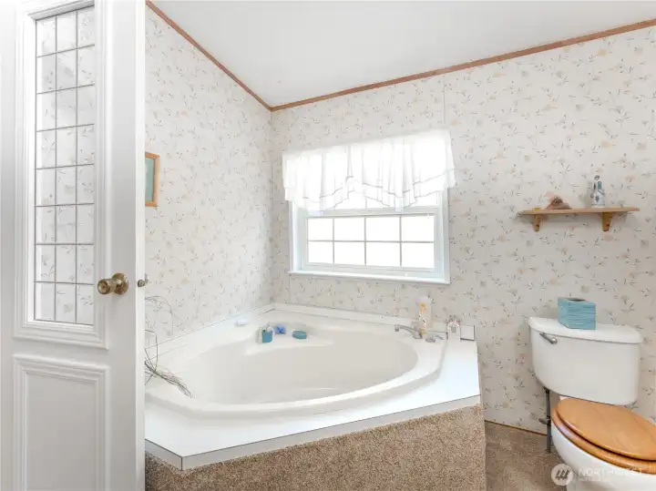 Five-piece primary en-suite featuring soaking tub and step-in shower