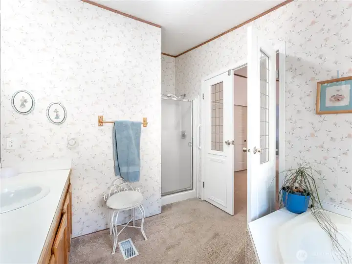 Five-piece primary en-suite featuring soaking tub and step-in shower