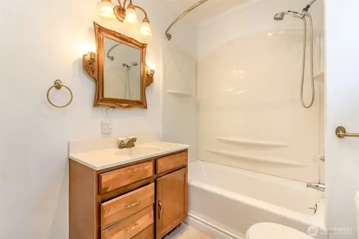 The bathroom features a bathtub and shower combo, offering both comfort and convenience.