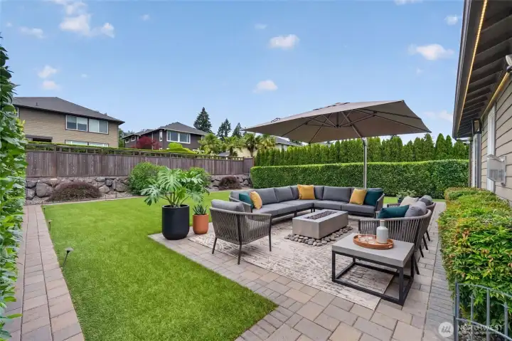 Expansive paver patio extends outdoor living possibilities. Wired patio lighting enhances evening gatherings.